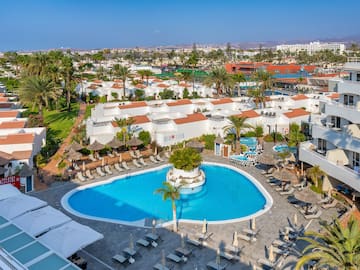 a pool and buildings with palm trees