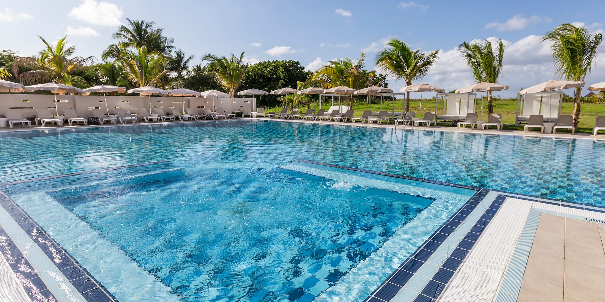 a pool with chairs and umbrellas