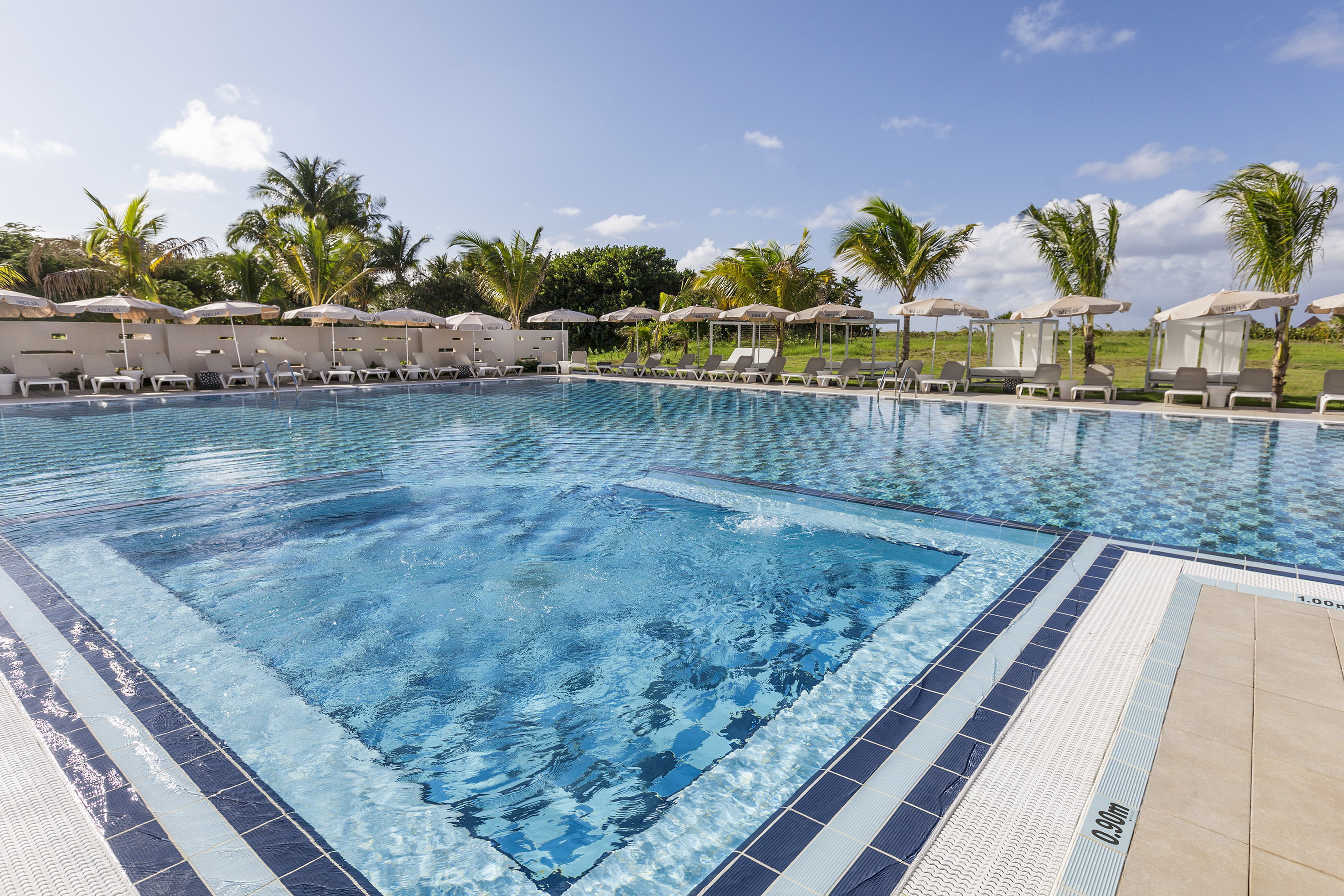 a pool with chairs and umbrellas