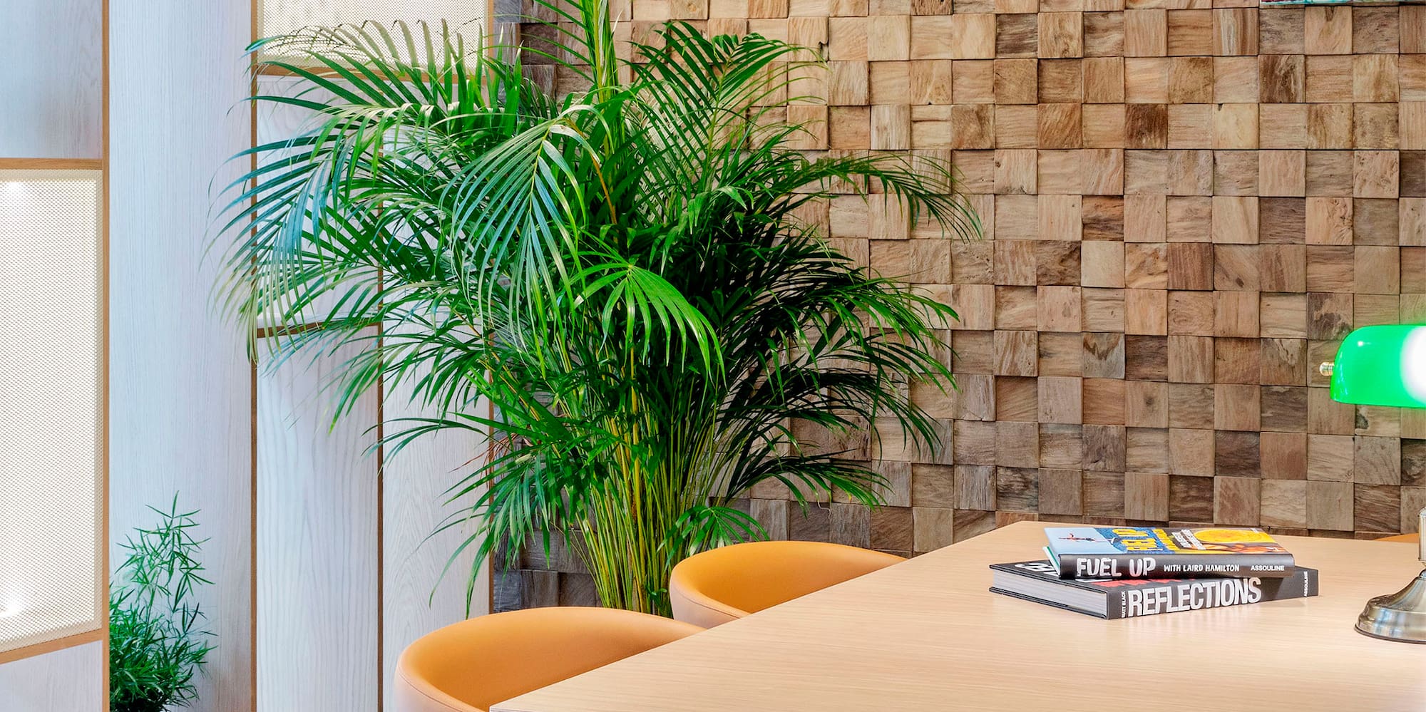 a table with chairs and a lamp in front of a wall