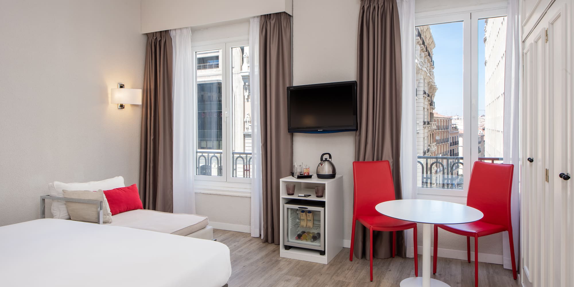 a room with a bed and a table and chairs