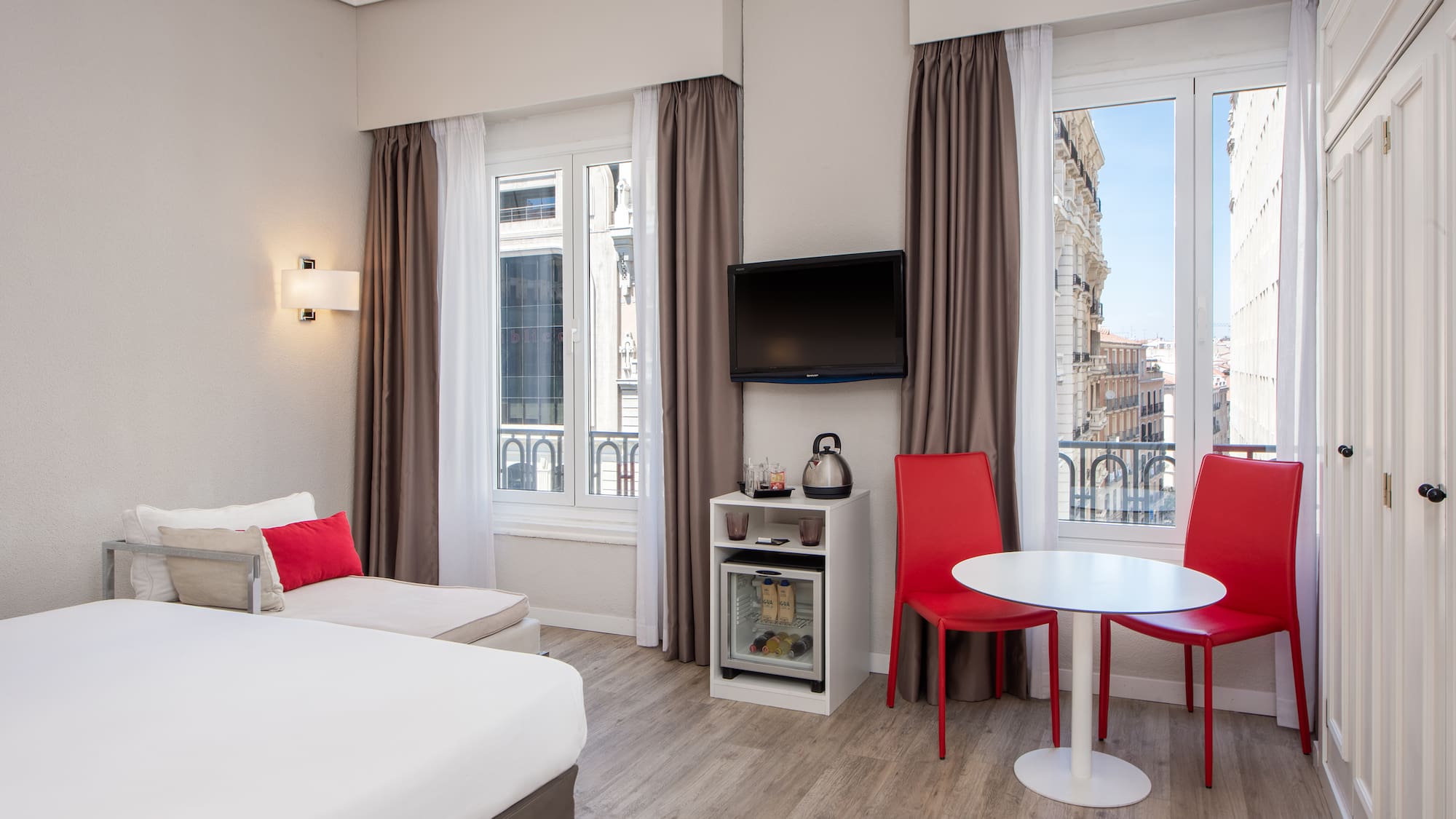 a room with a bed and a table and chairs