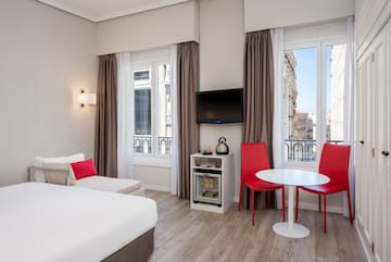 a room with a bed and a table and chairs