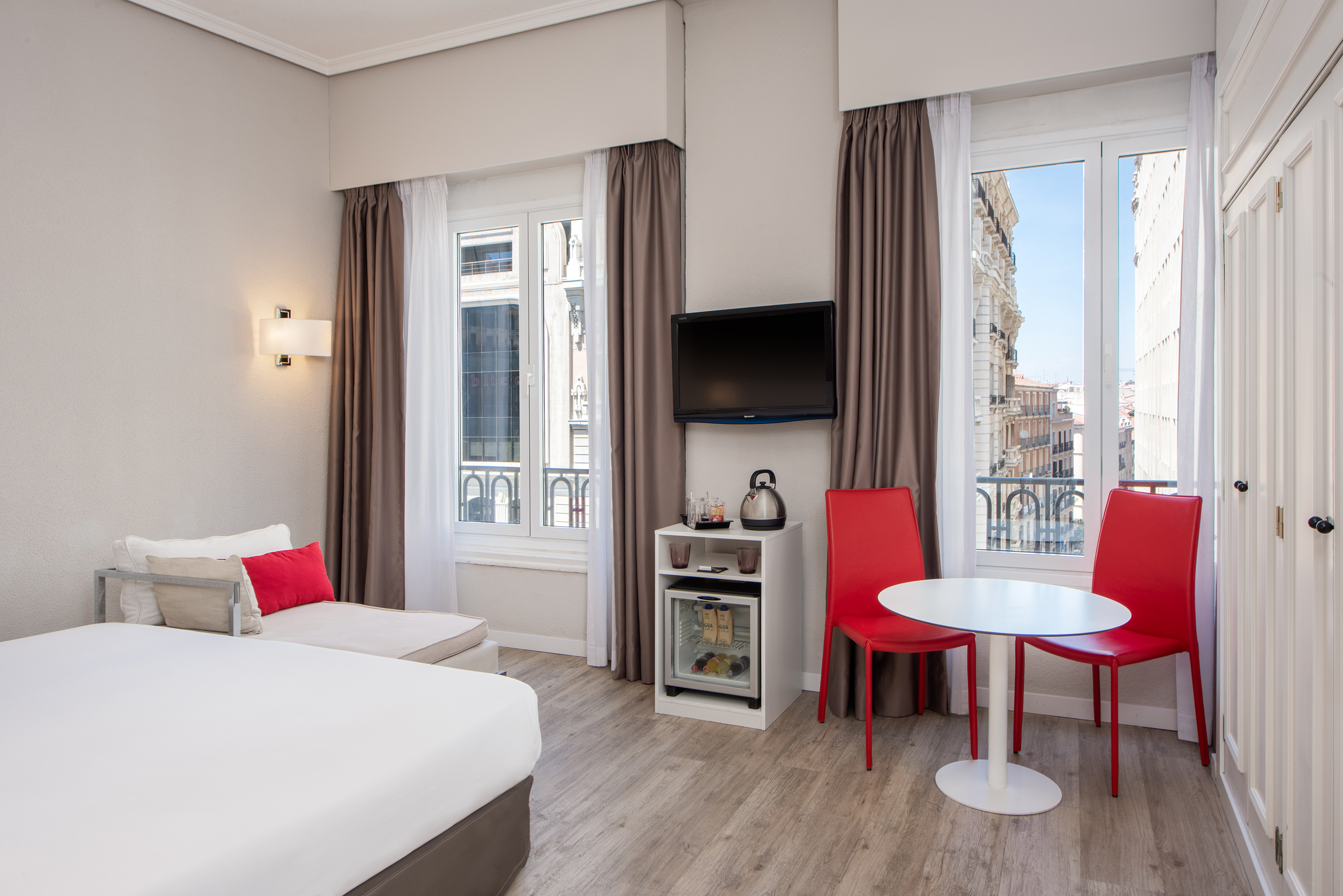 a room with a bed and a table and chairs
