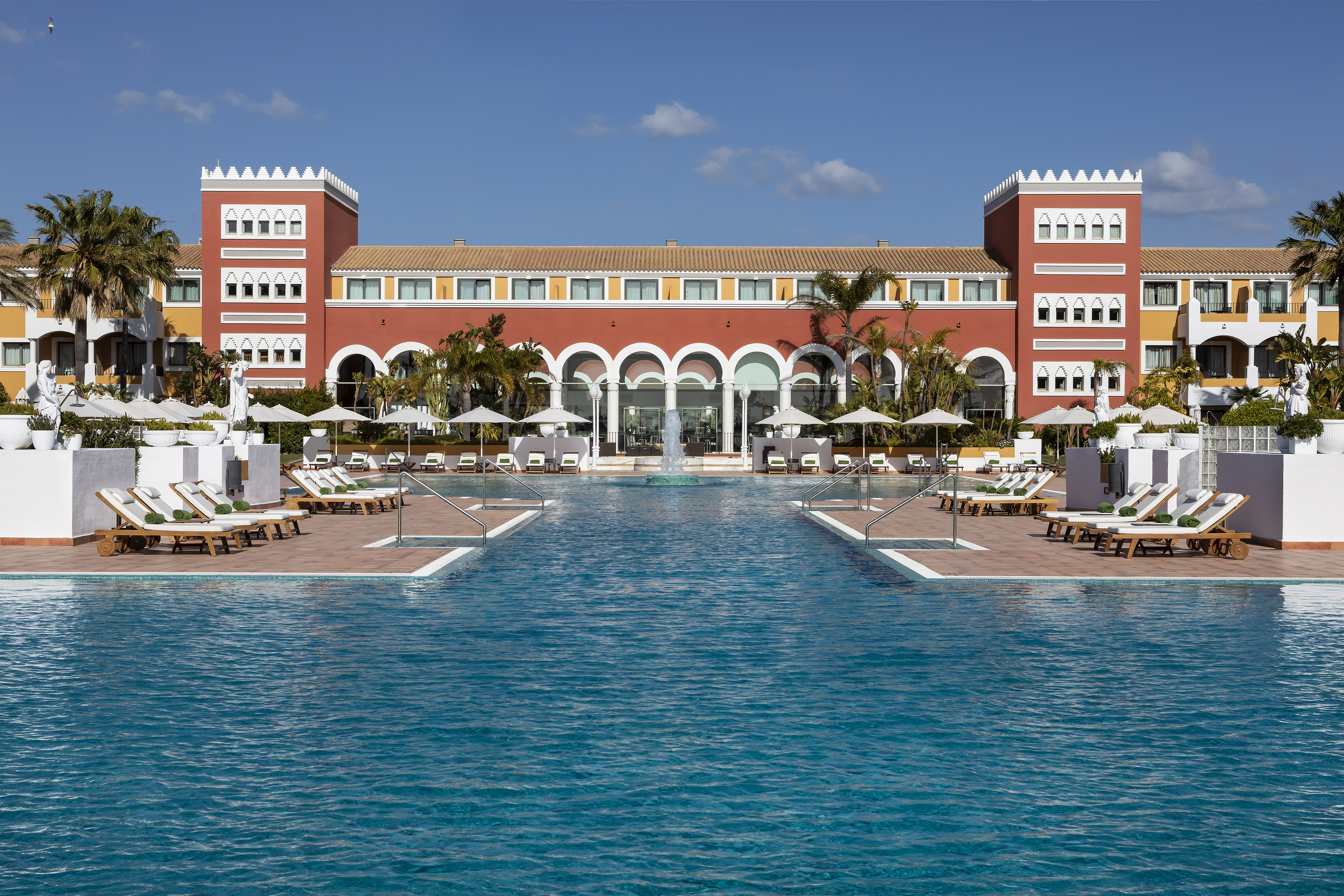 a pool with chairs and a building
