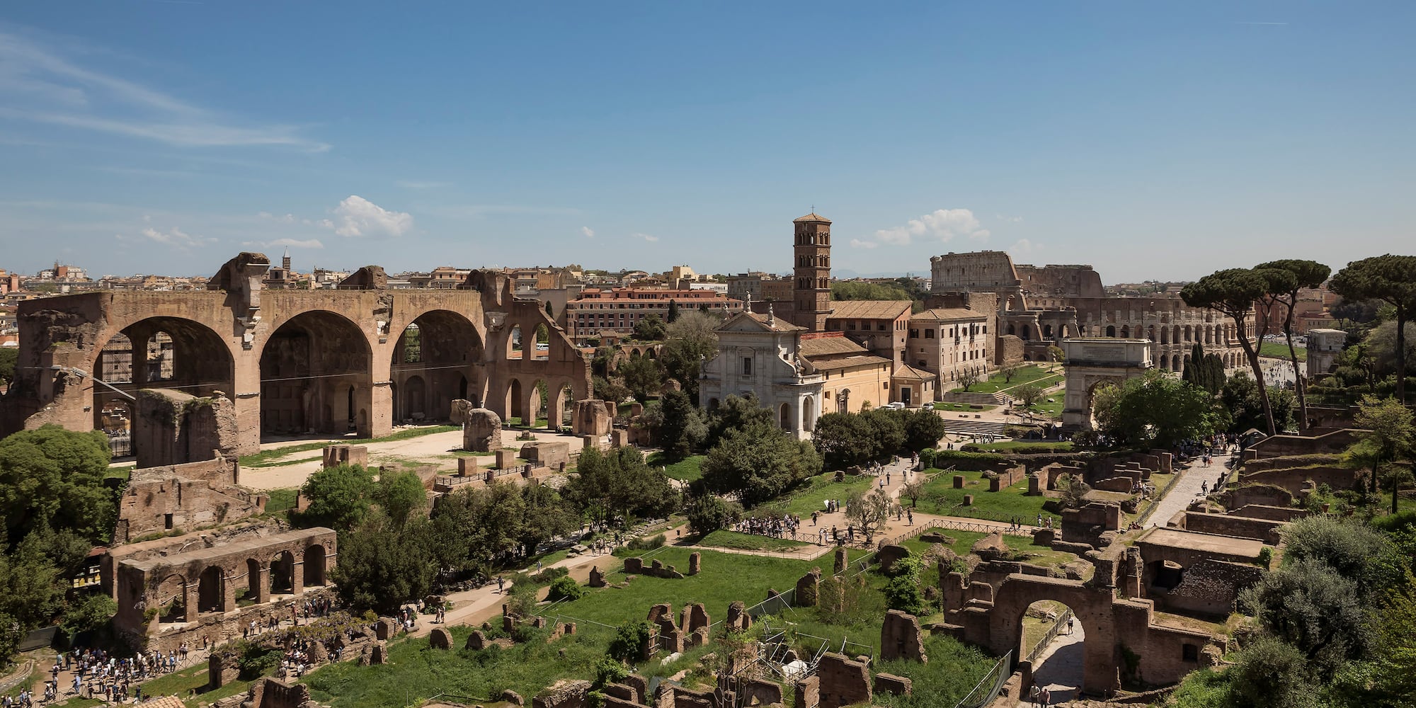 an old city with ruins with Roman Forum in the background