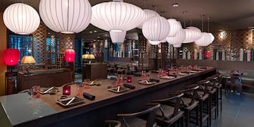 a long table with white lanterns from the ceiling