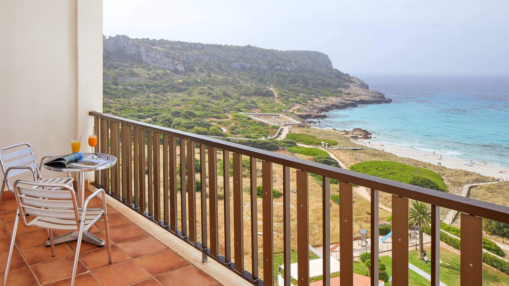 a balcony with a table and chairs overlooking a body of water