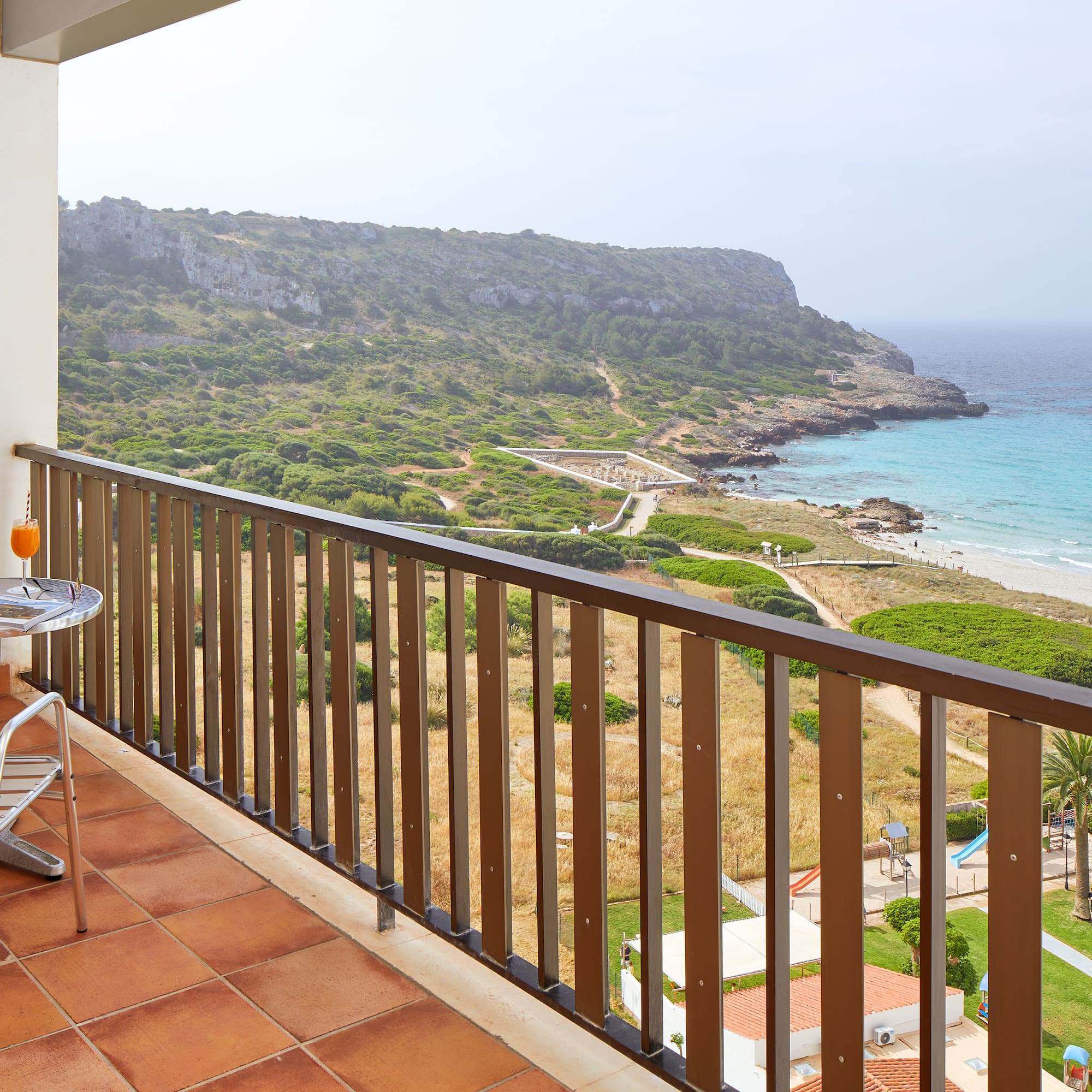 a balcony with a table and chairs overlooking a body of water