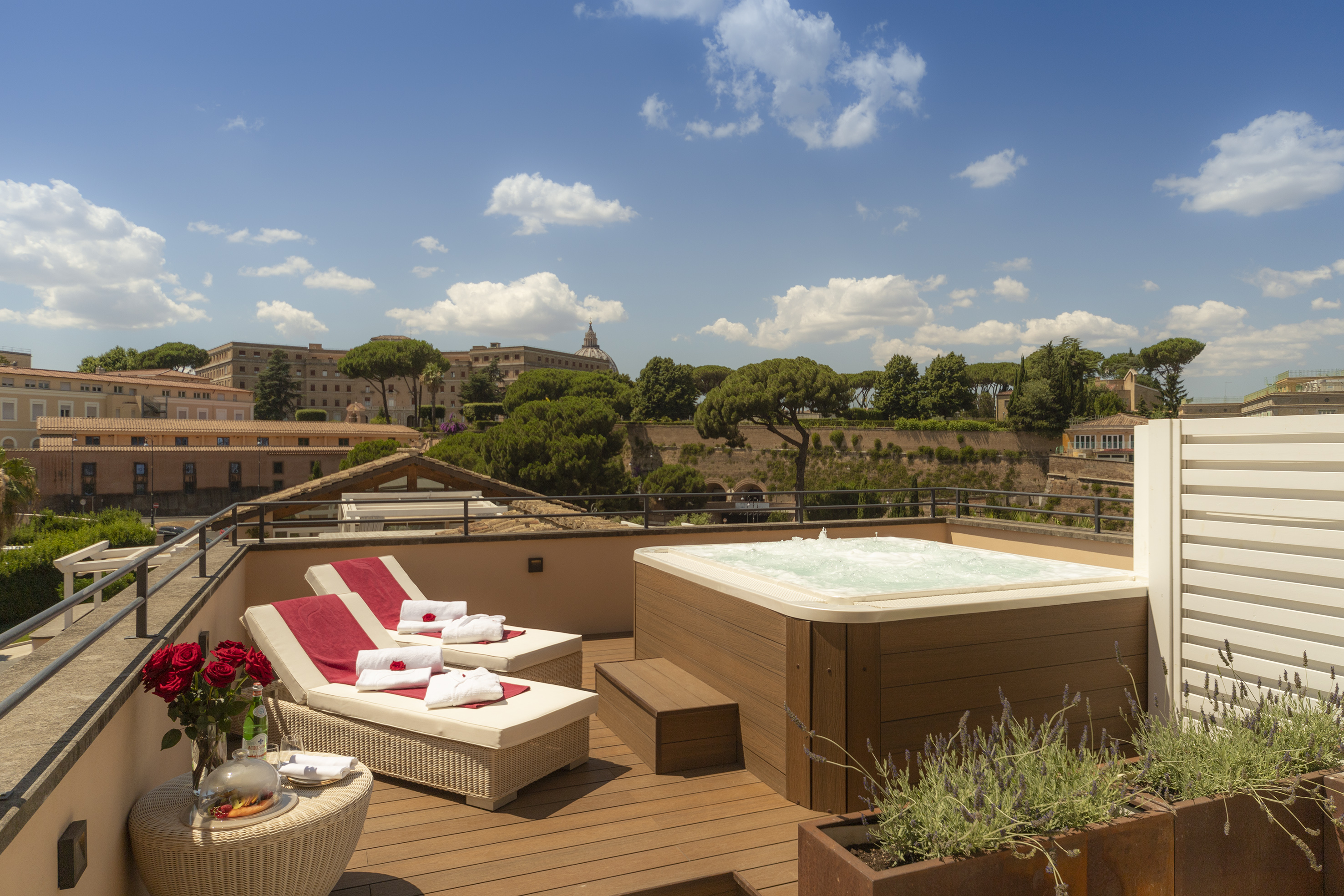 Roman rooftop terrace featuring hot tub, sunbeds, and Vatican City views.