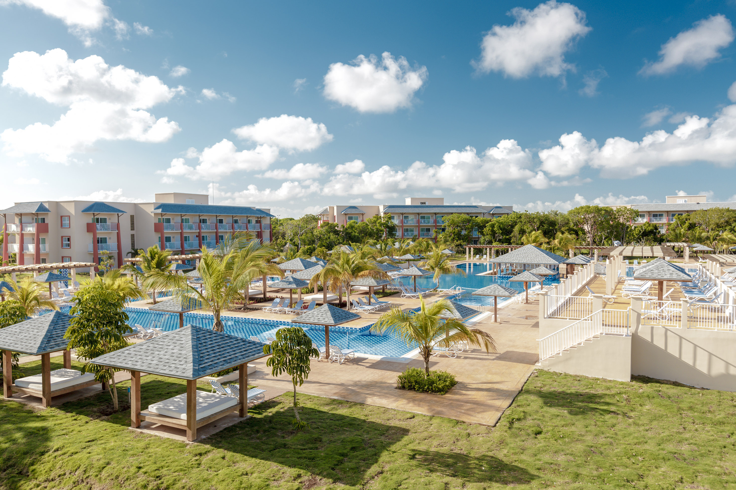 a pool with umbrellas and lounge chairs in a resort