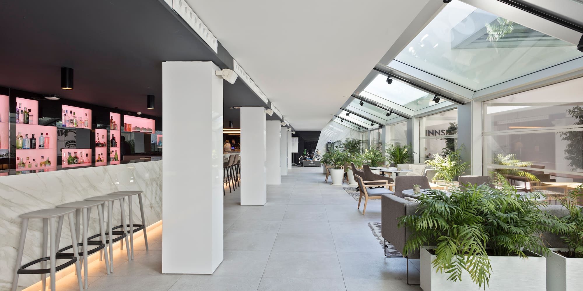 a room with white columns and tables and chairs