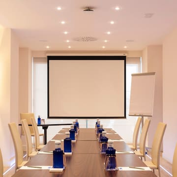 a room with a projection screen and a table with blue objects