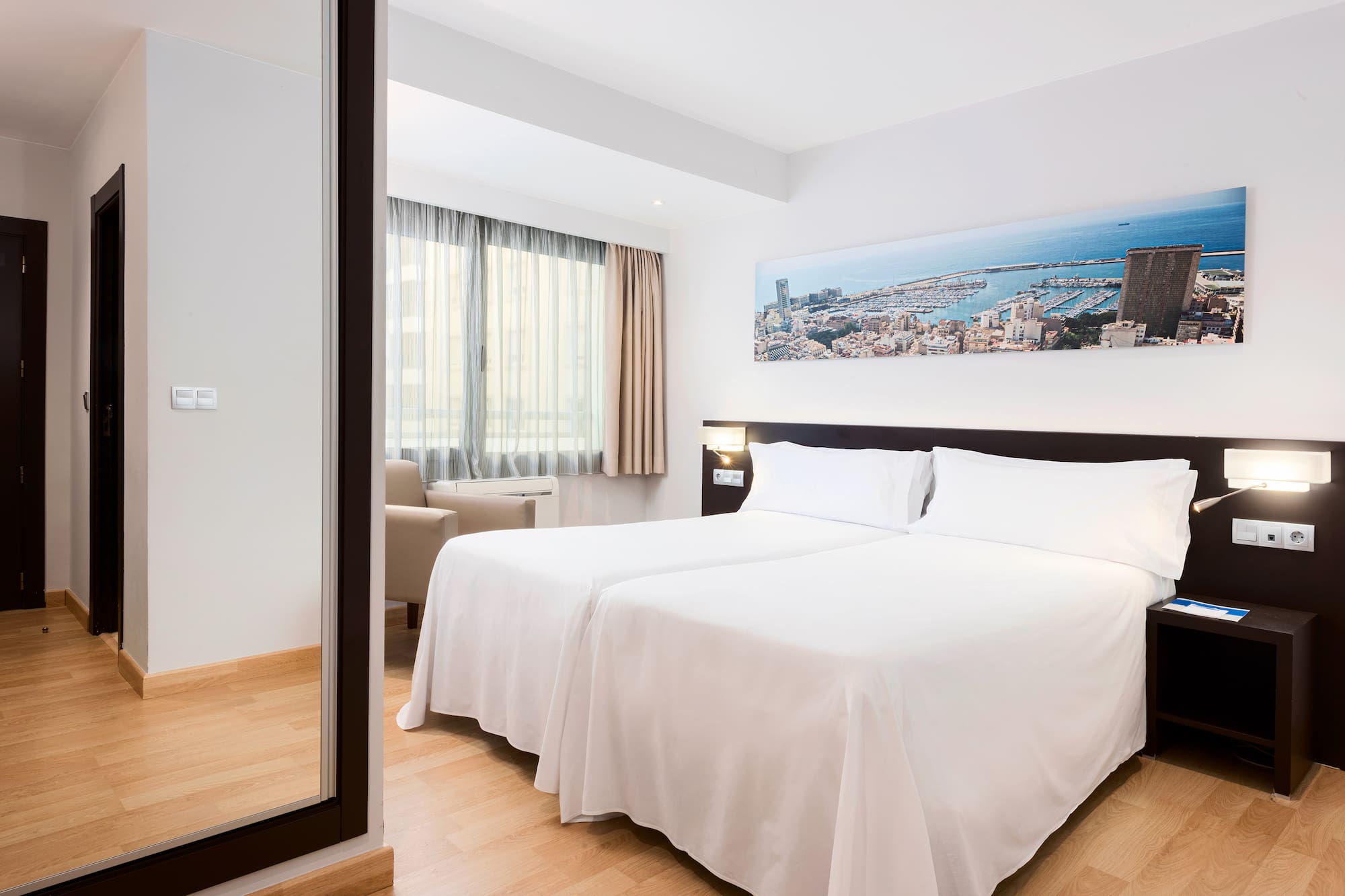 a room with two beds and a mirror