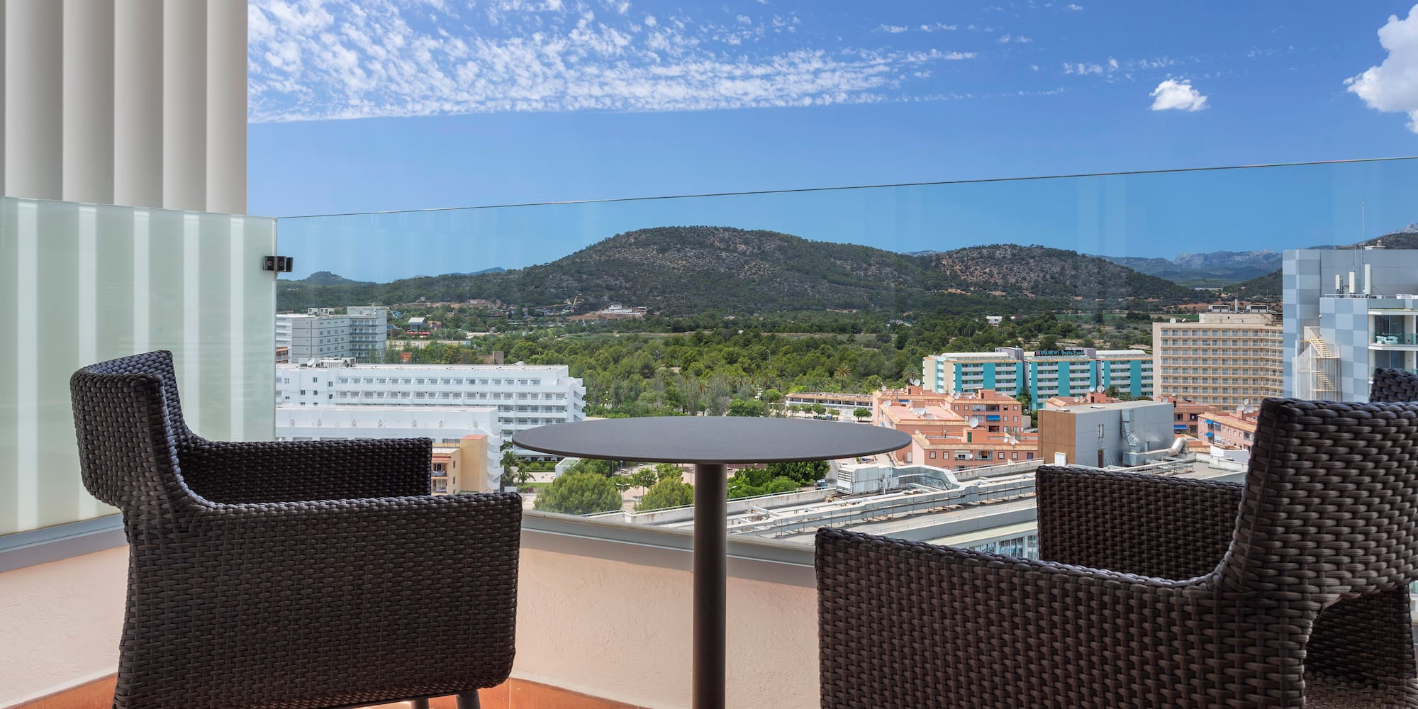 a table and chairs on a balcony overlooking a city