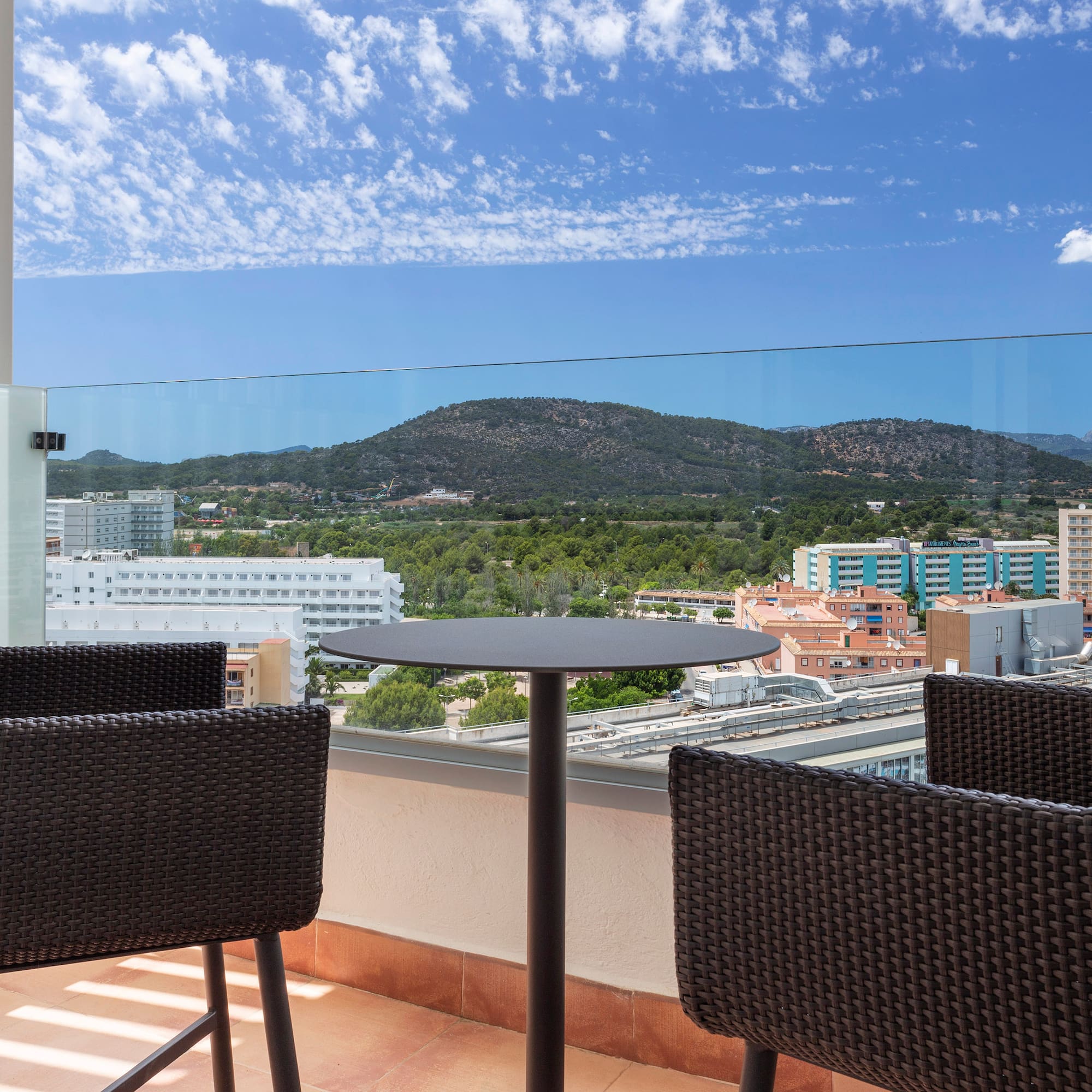 a table and chairs on a balcony overlooking a city