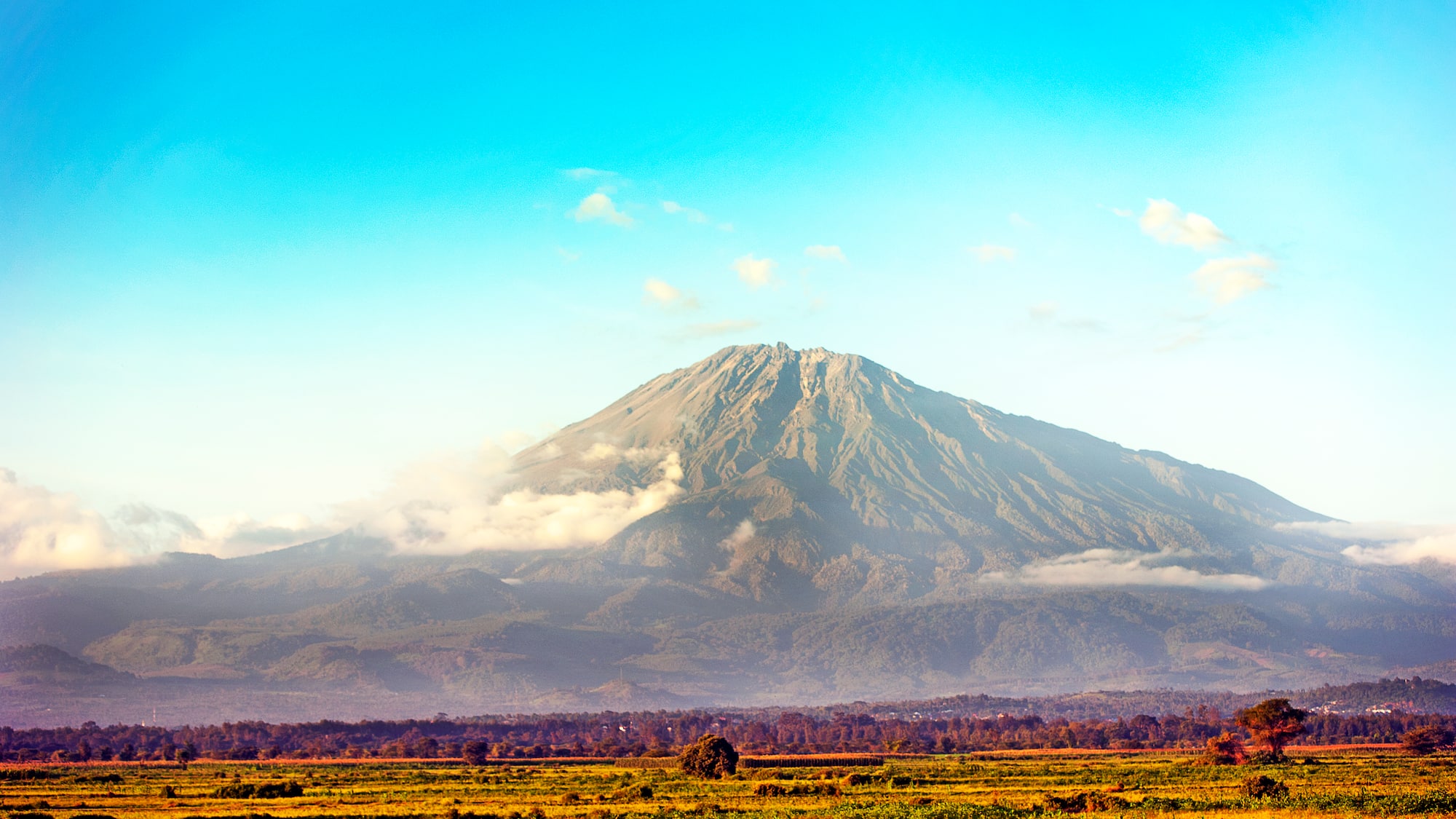 a mountain with clouds in the sky