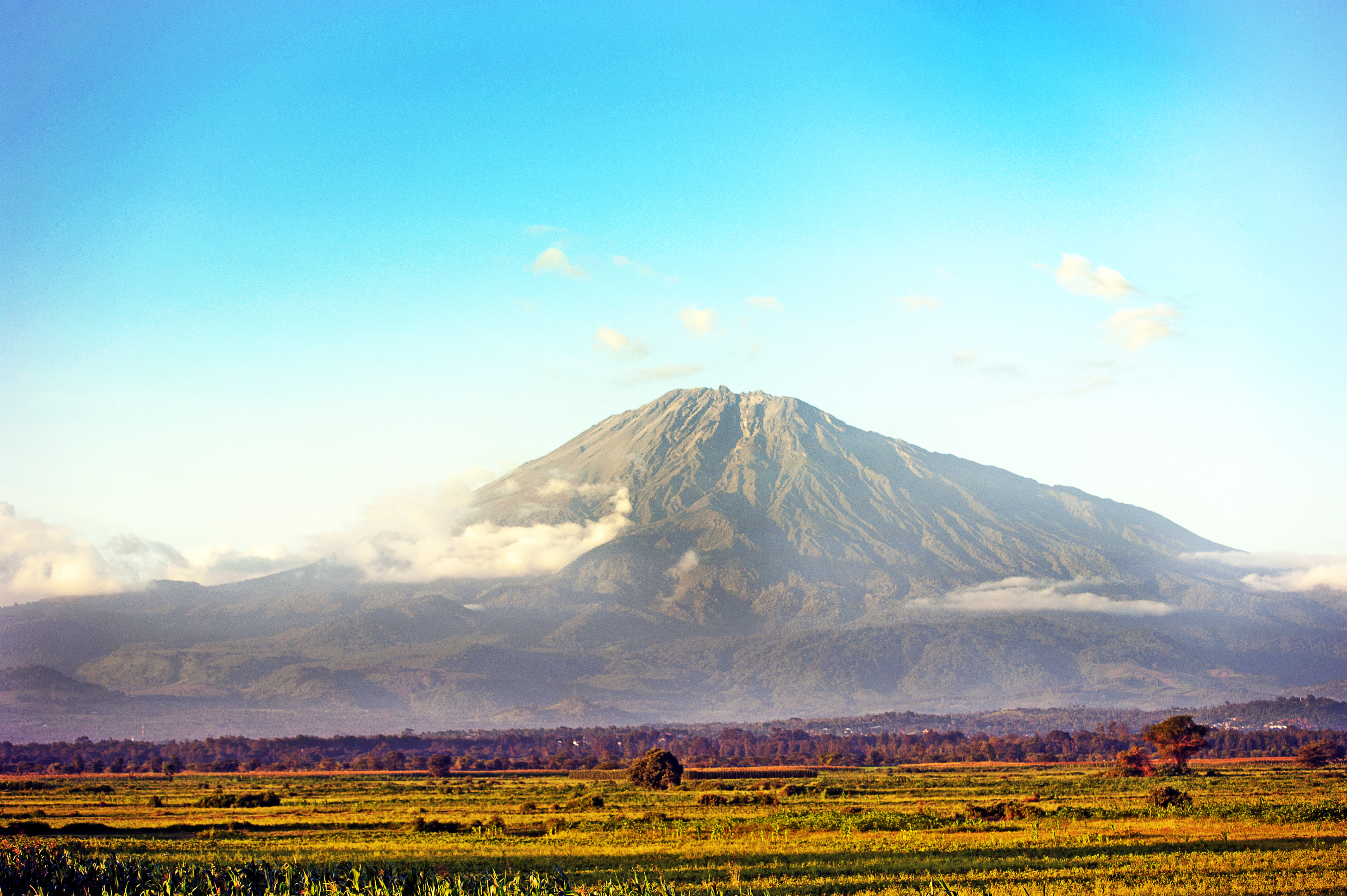 a mountain with clouds in the sky