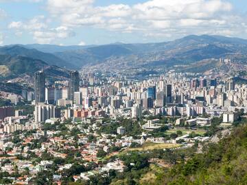 a city with many tall buildings and mountains in the background