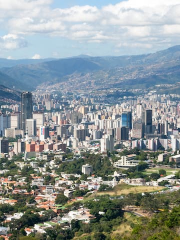 a city with many tall buildings and mountains in the background