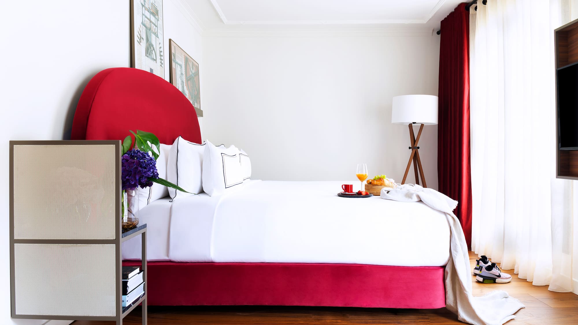 a bed with a tray of food and a lamp in a room