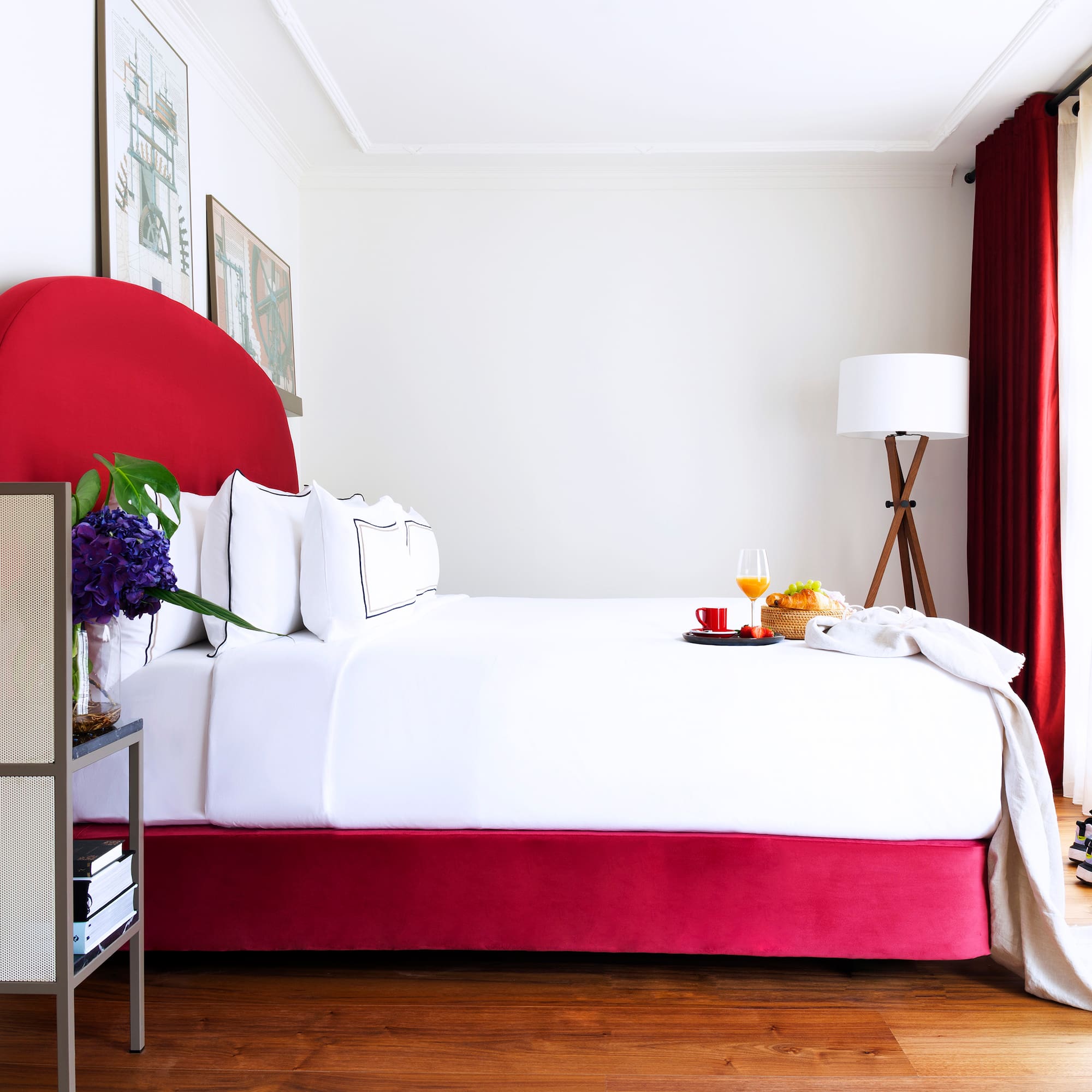 a bed with a tray of food and a lamp in a room