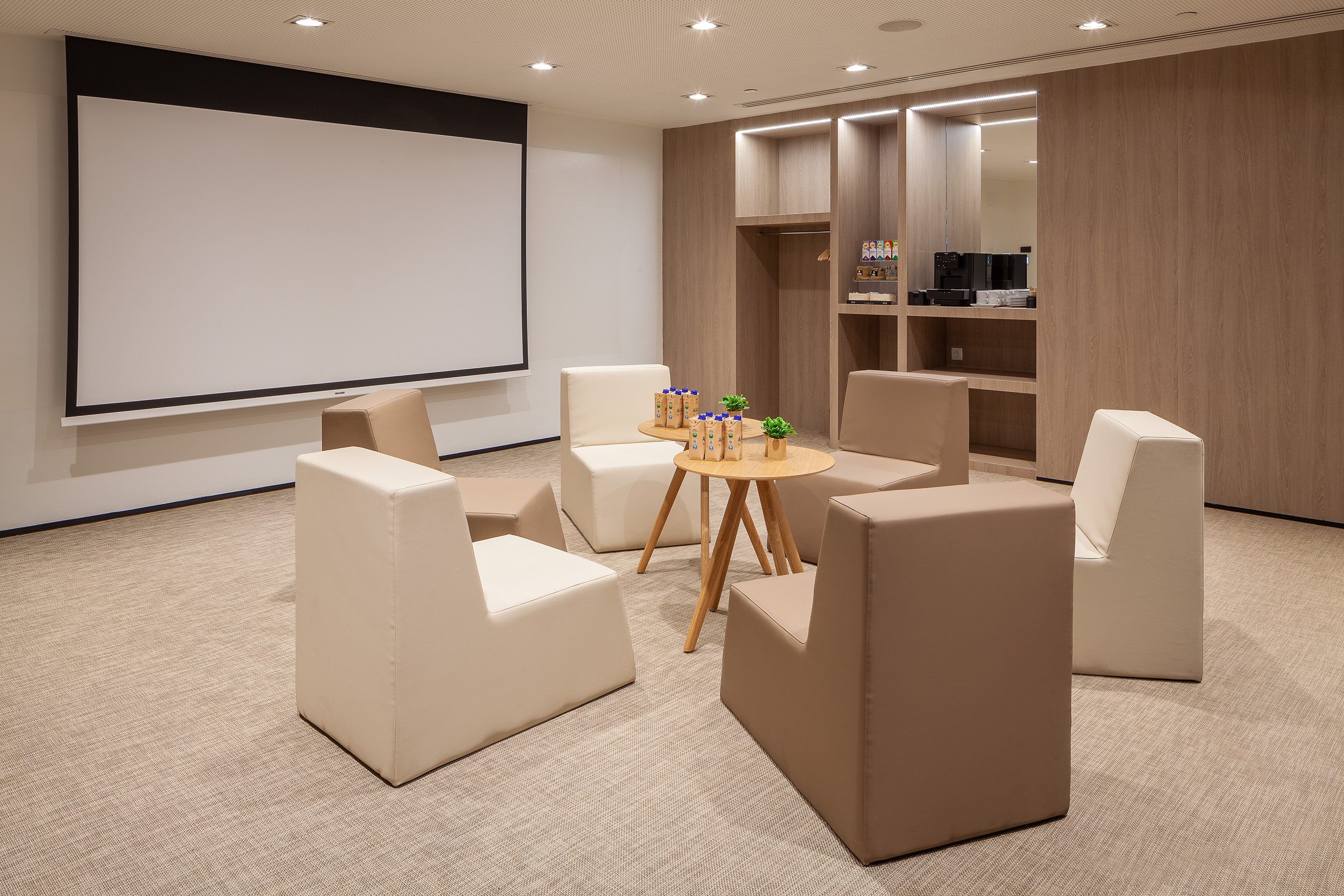 a room with a projector screen and chairs