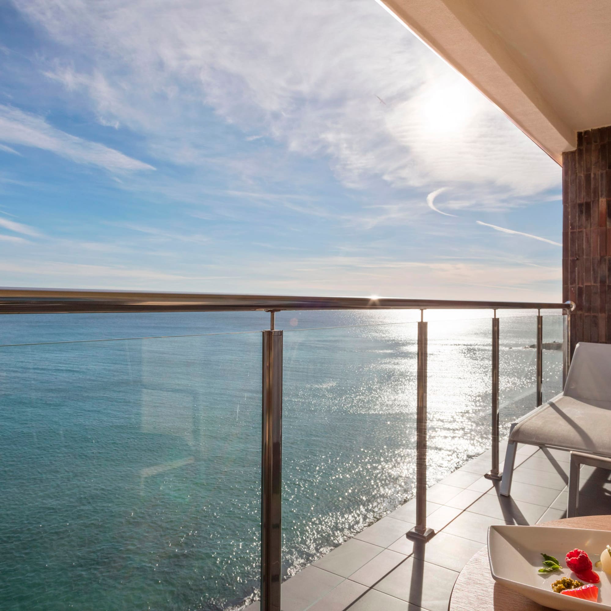 a deck with a table and chairs overlooking the water