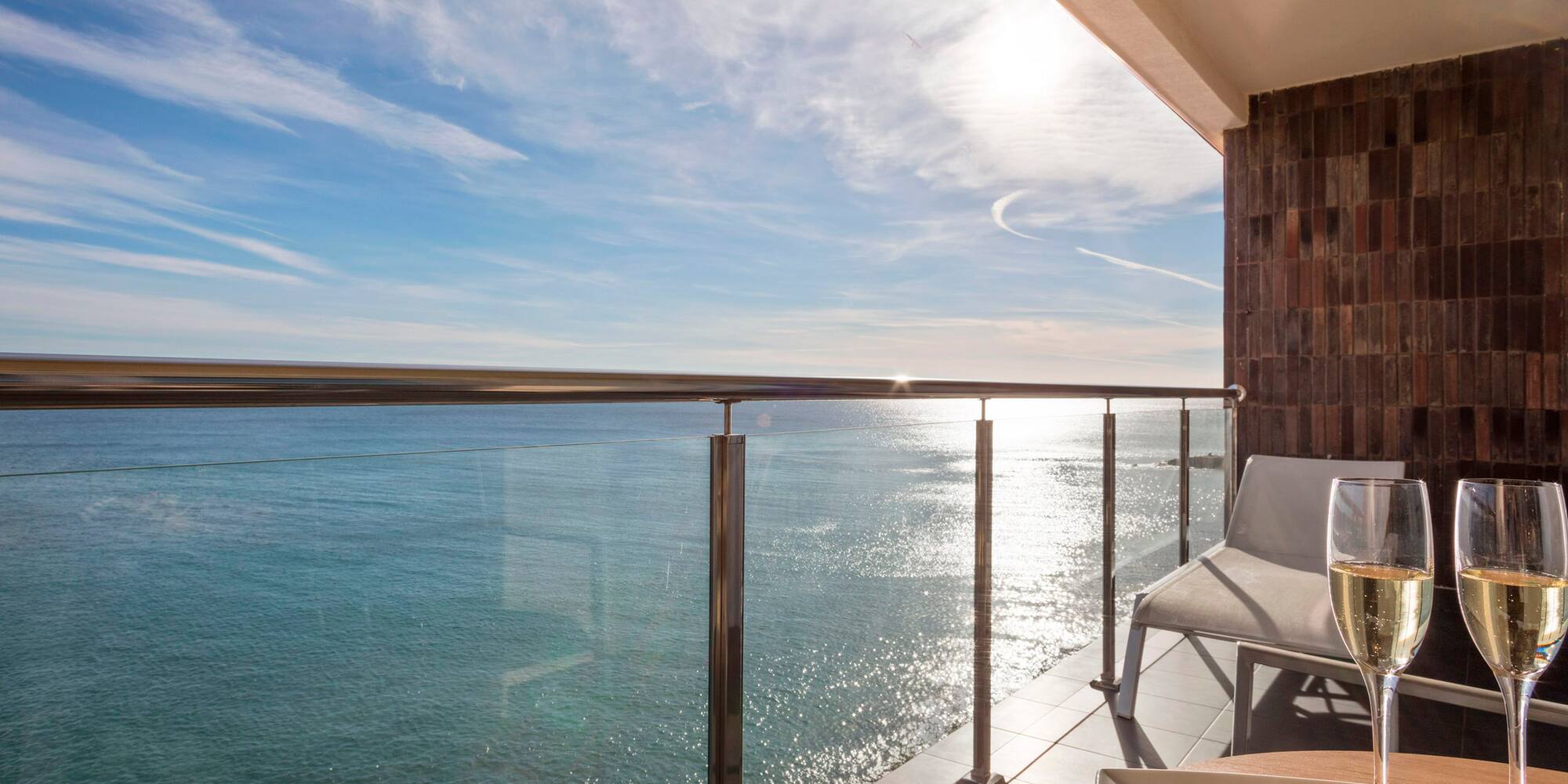 a deck with a table and chairs overlooking the water