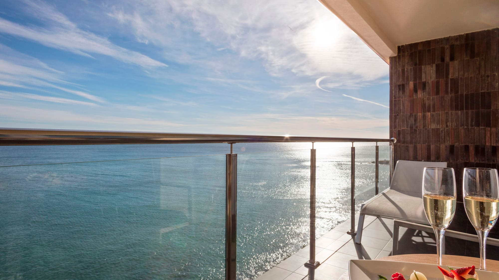 a deck with a table and chairs overlooking the water