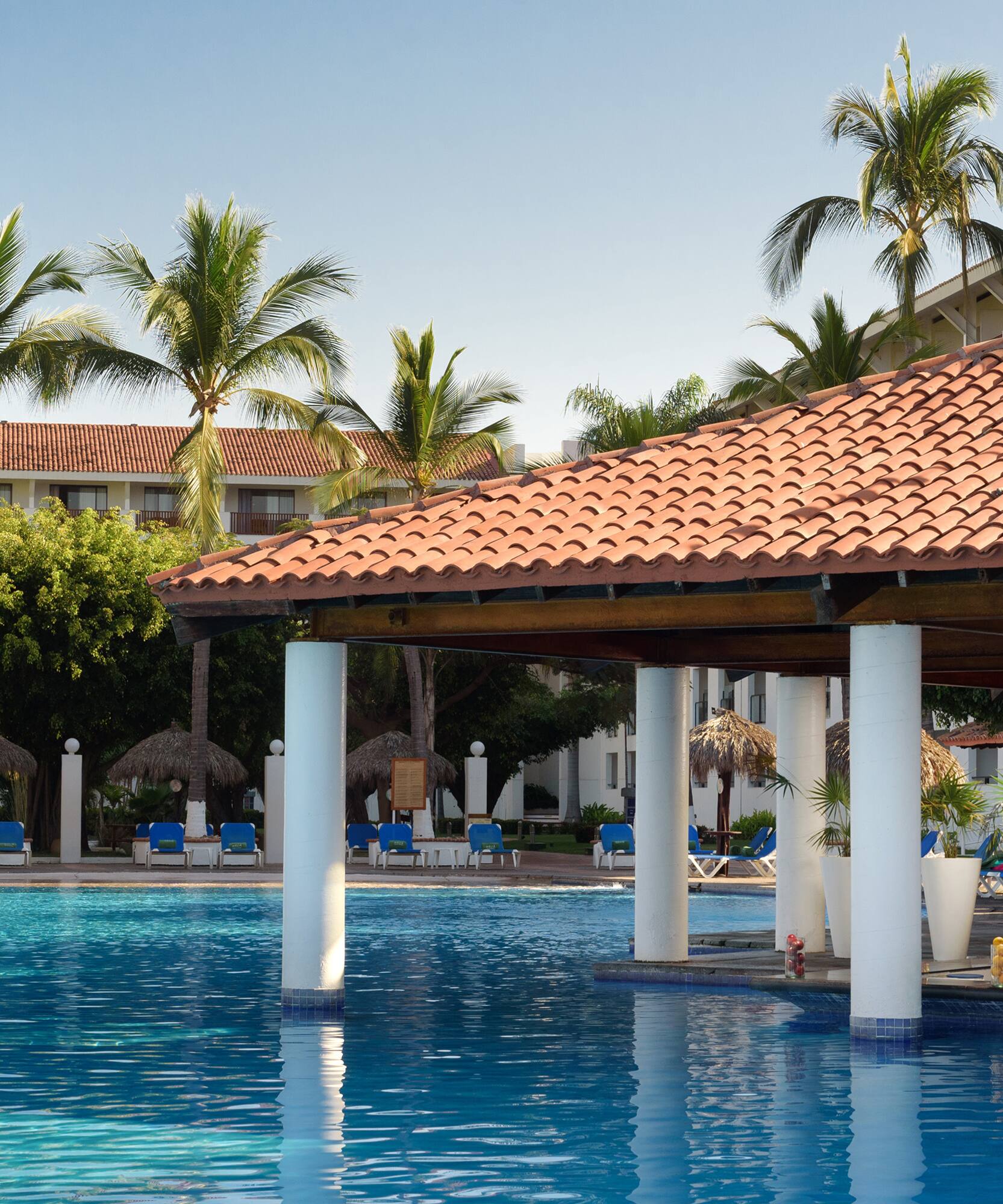 a pool with a roof and chairs