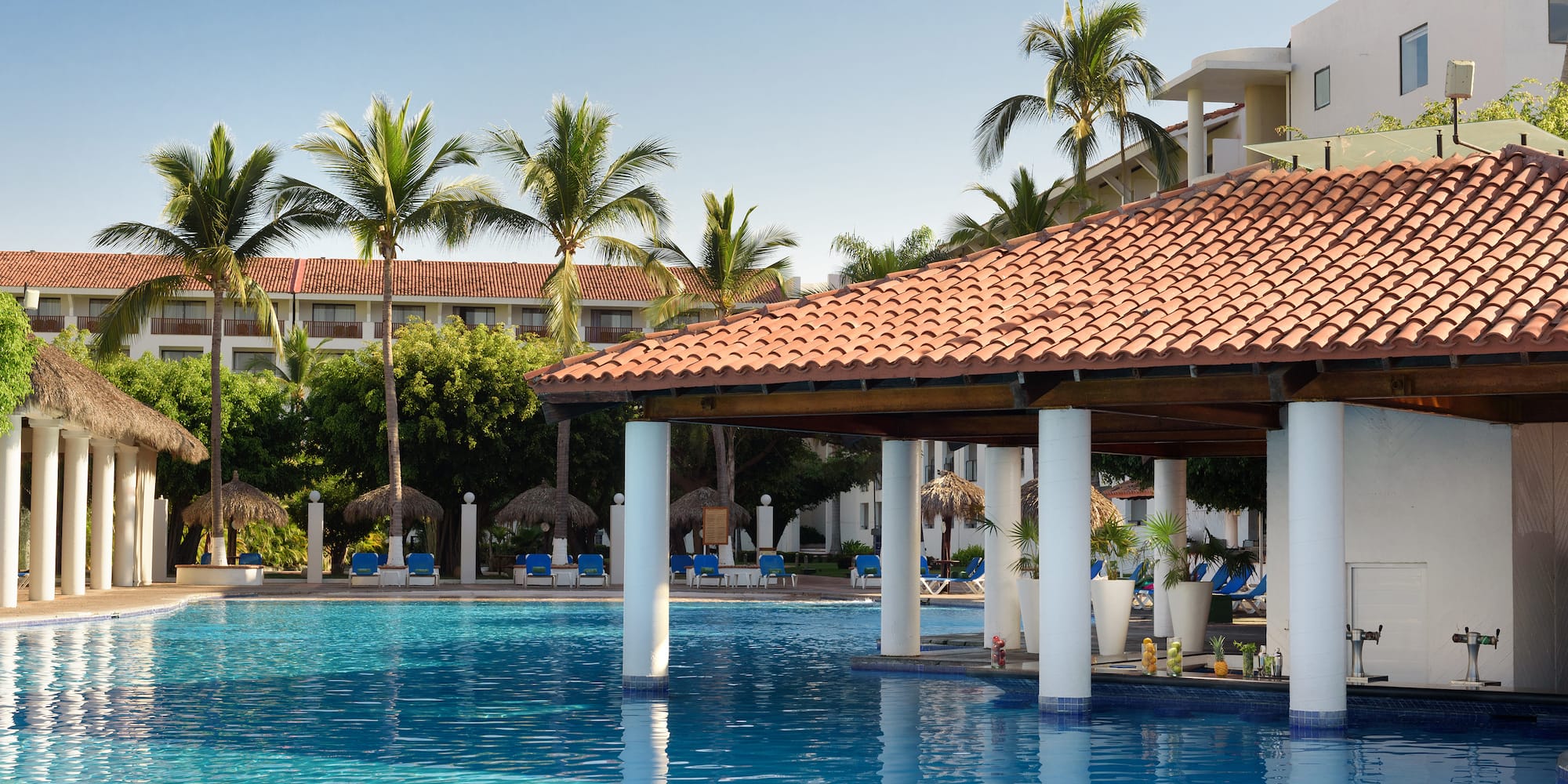 a pool with a roof and chairs