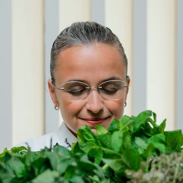 a woman looking at a bunch of leaves