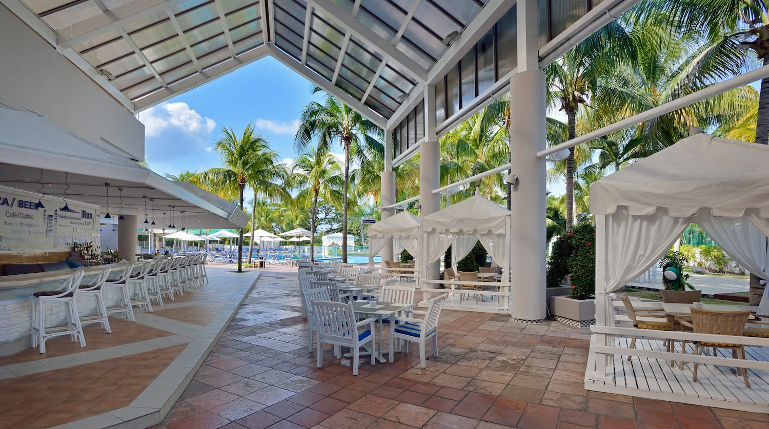 a patio with tables and chairs and umbrellas