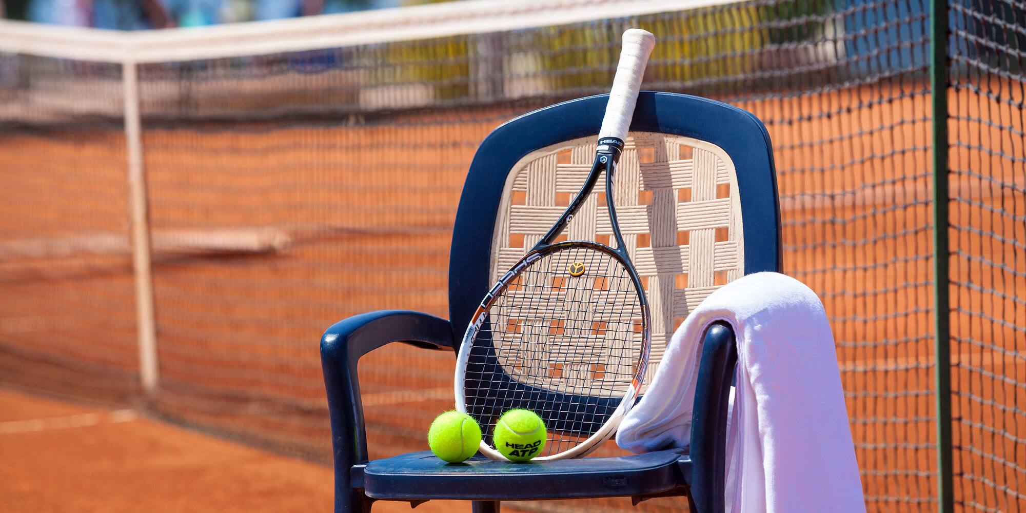 a tennis racket and balls on a chair