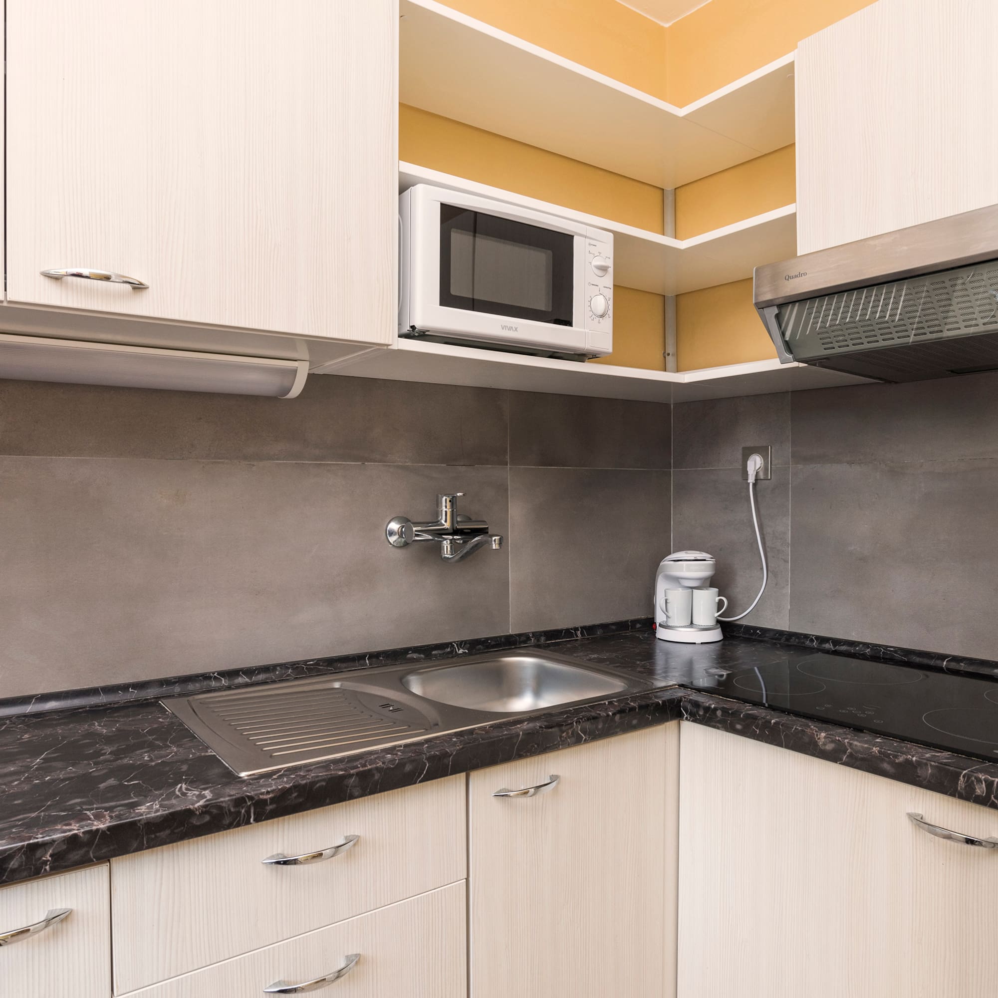 a kitchen with white cabinets and black counter tops