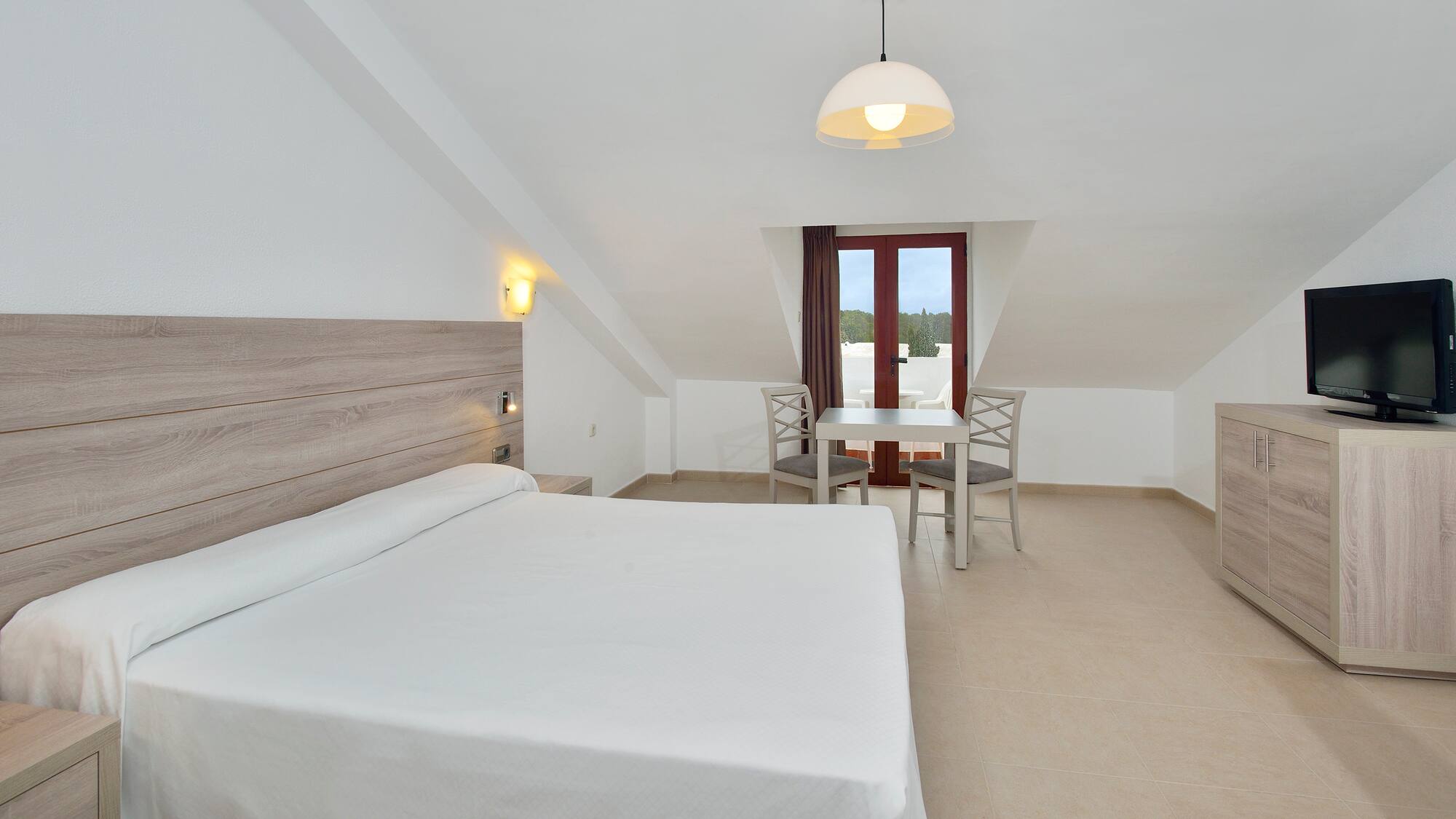 a room with a bed and chairs