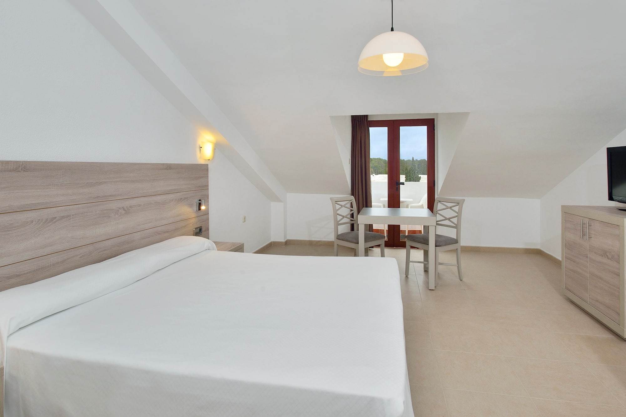 a room with a bed and chairs