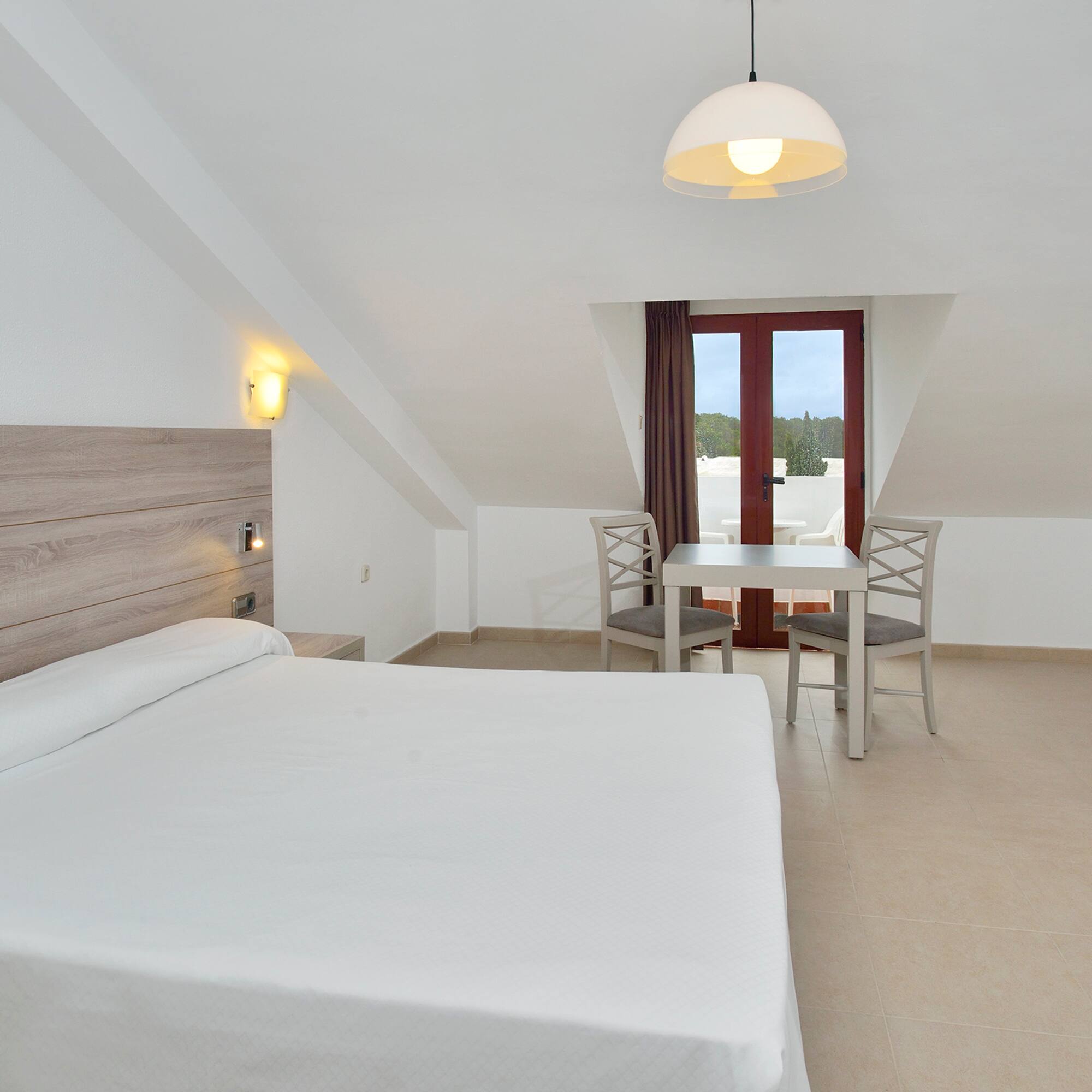 a room with a bed and chairs