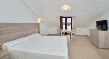 a room with a bed and chairs