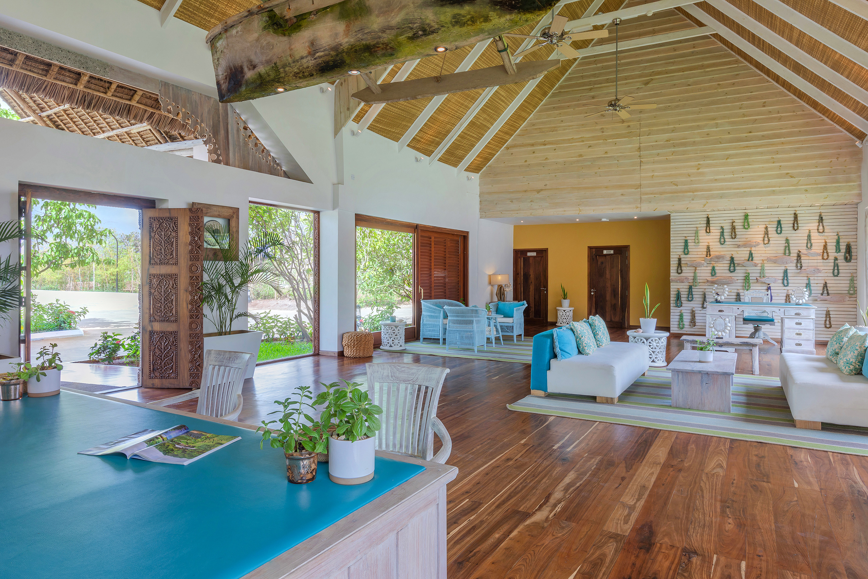 Tropical resort lounge with vaulted ceilings, hardwood floors, and canoe decor.
