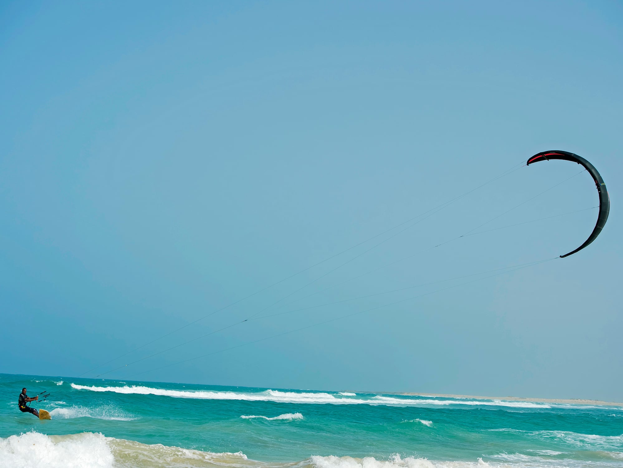 a person flying a kite over the ocean