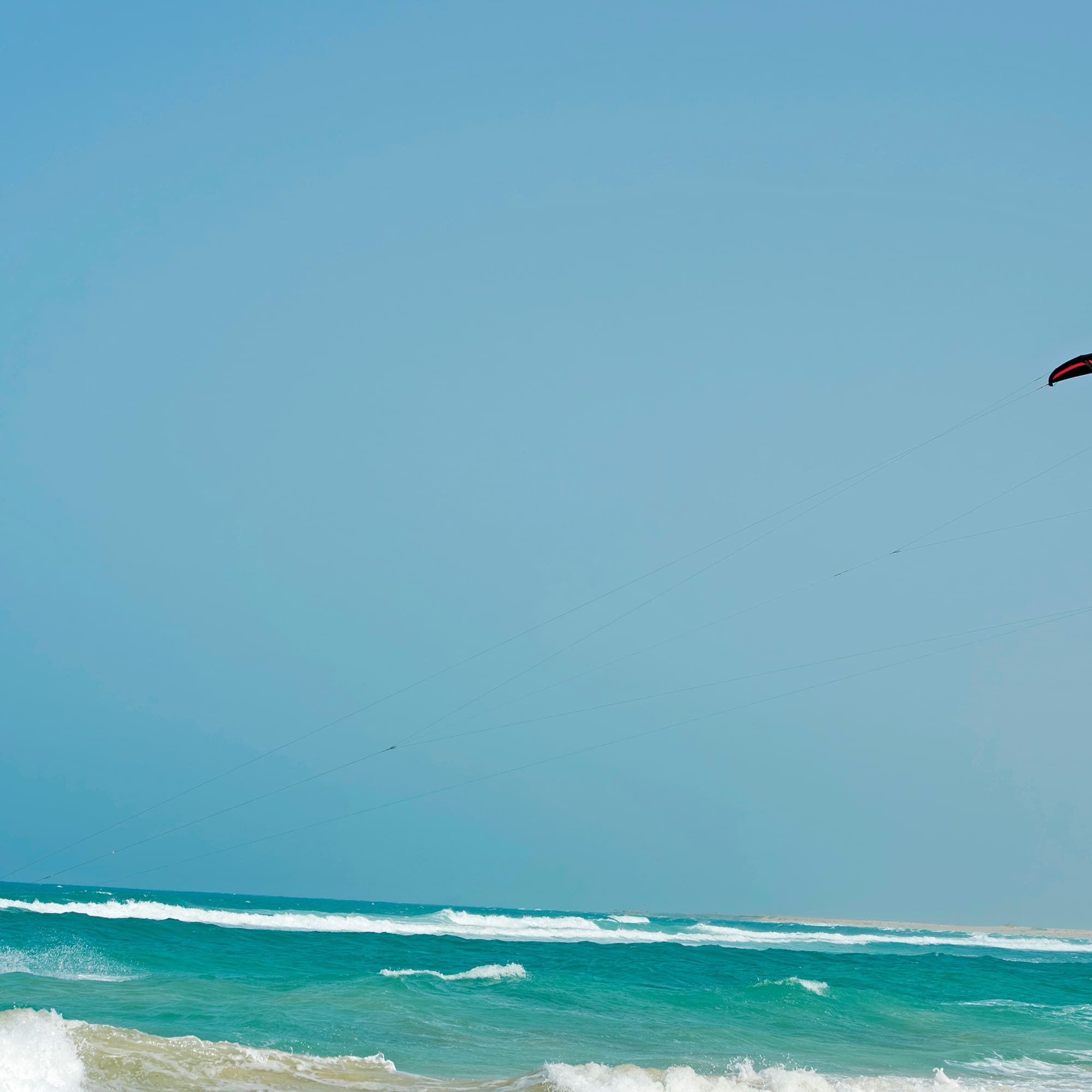 a person flying a kite over the ocean