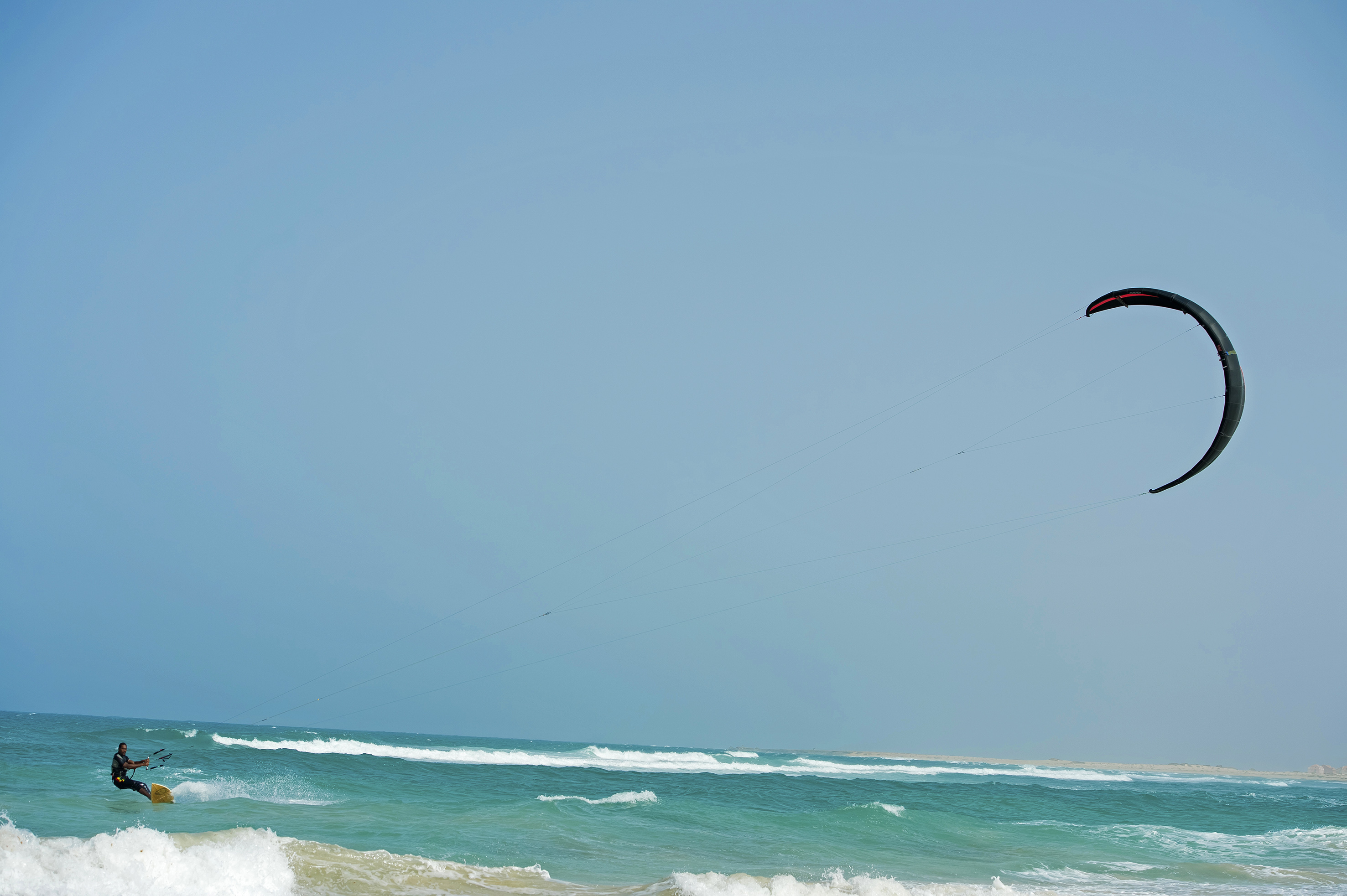 a person flying a kite over the ocean