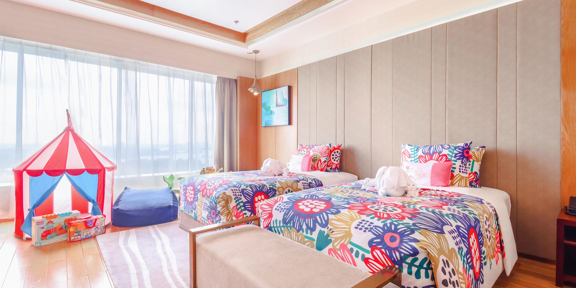 a room with two beds and a pink tent