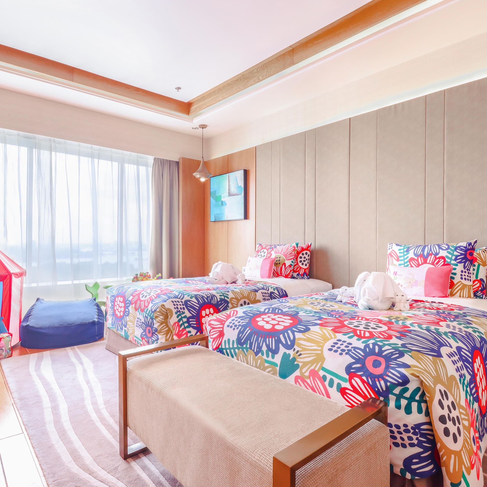 a room with two beds and a pink tent