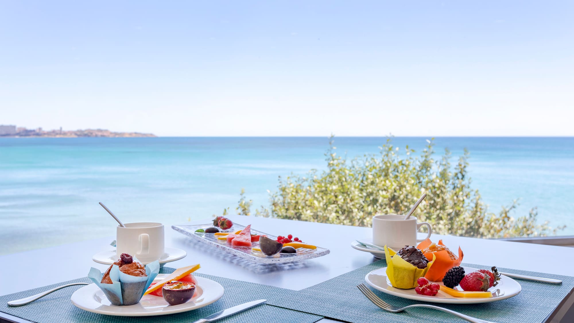 a table with plates of food and a cup of coffee on it