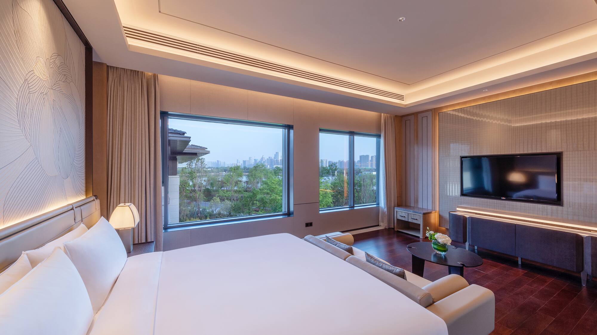 a room with a large bed and a television