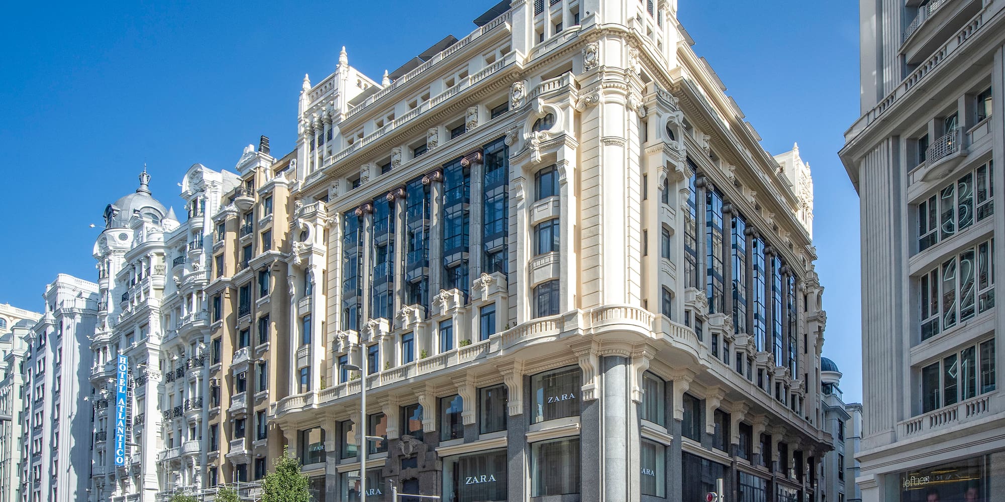 a street with a large building and people walking on it