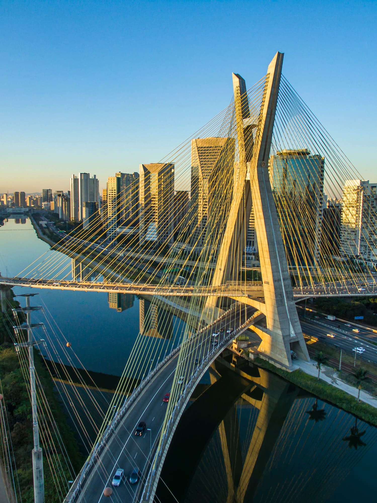 a bridge over a river with a city in the background